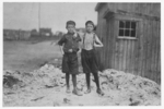 Lewis Hine child labor: Two young carrying-in boys in Alexandria (Va.) Glass Factory. Frank Clark (on left) 702 N. Patrick St., could neither read nor write, having been to school only a few weeks in his life. Two older brothers work in glass factory, and his father is a candy maker. Frank is working on night shift this week. Ashby Corbin (on right), 413 N. St. Asaph St. Has had only four terms of schooling. See also photos and labels 2260 to 2271. Location: Alexandria, Virginia.